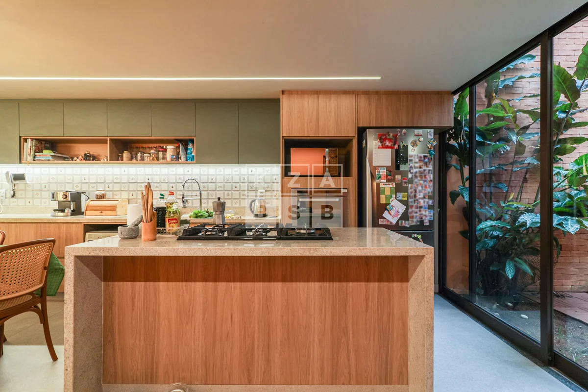 Logo na entrada, o olhar atravessa a casa inteira — ela é vazada, livre, viva. O...